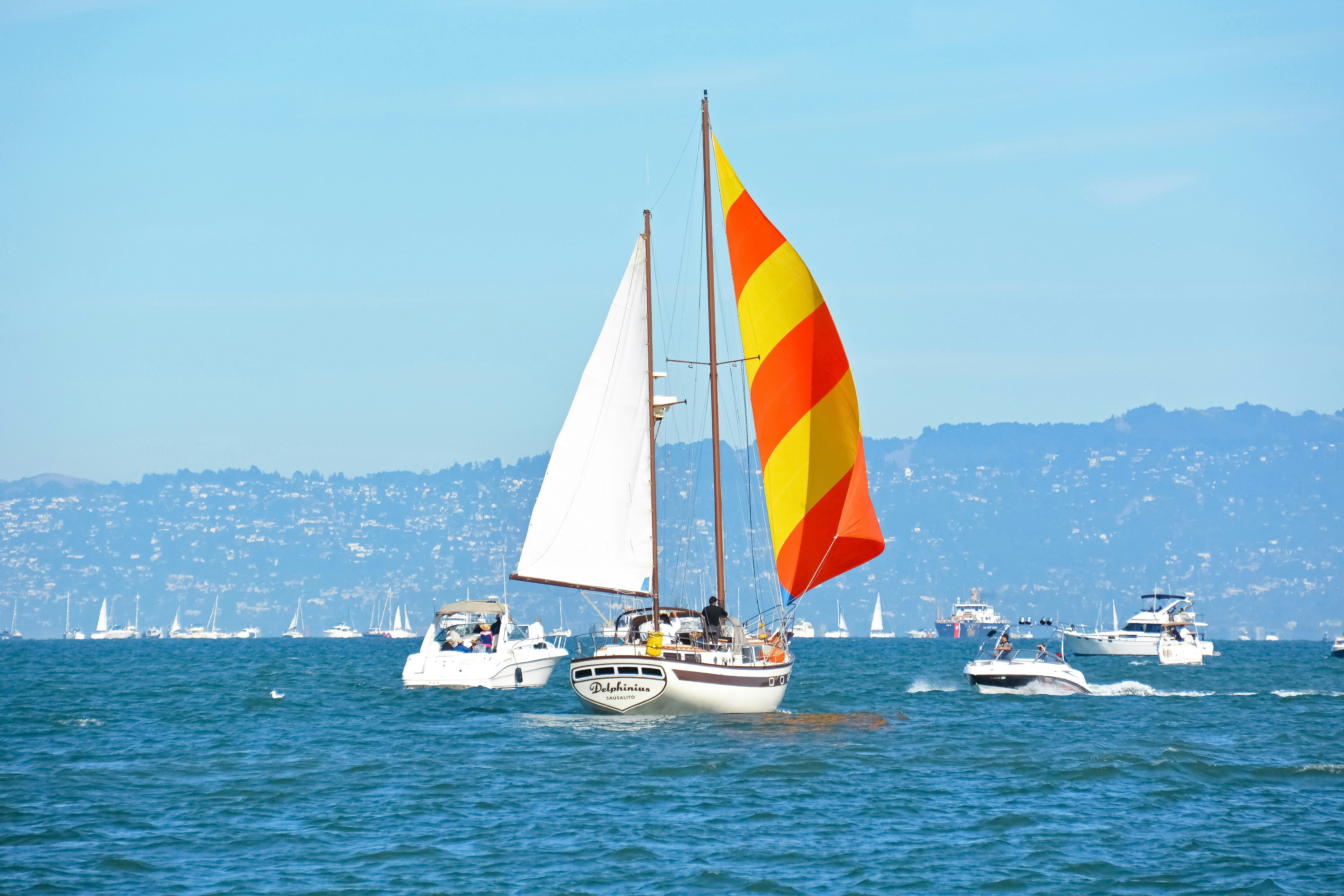 white and red sail boat on sea during daytime